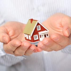 Miniture home model being held in a person's hands